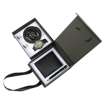 Set of black leather accessories including a belt, wallet, and pen in an open box on a white background.